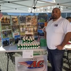 American Comrades co-founder standing in front of raffle prizes