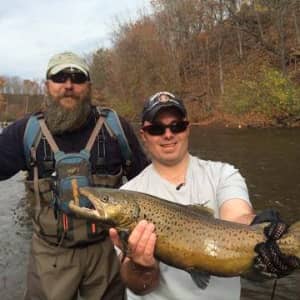 Recipients showcase a fish caught on a fishing trip organized by American Comrades.